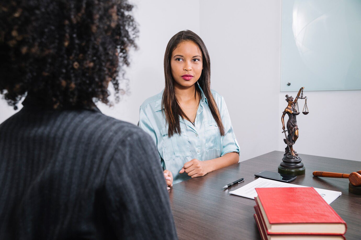 A woman sitting at a table with another person.