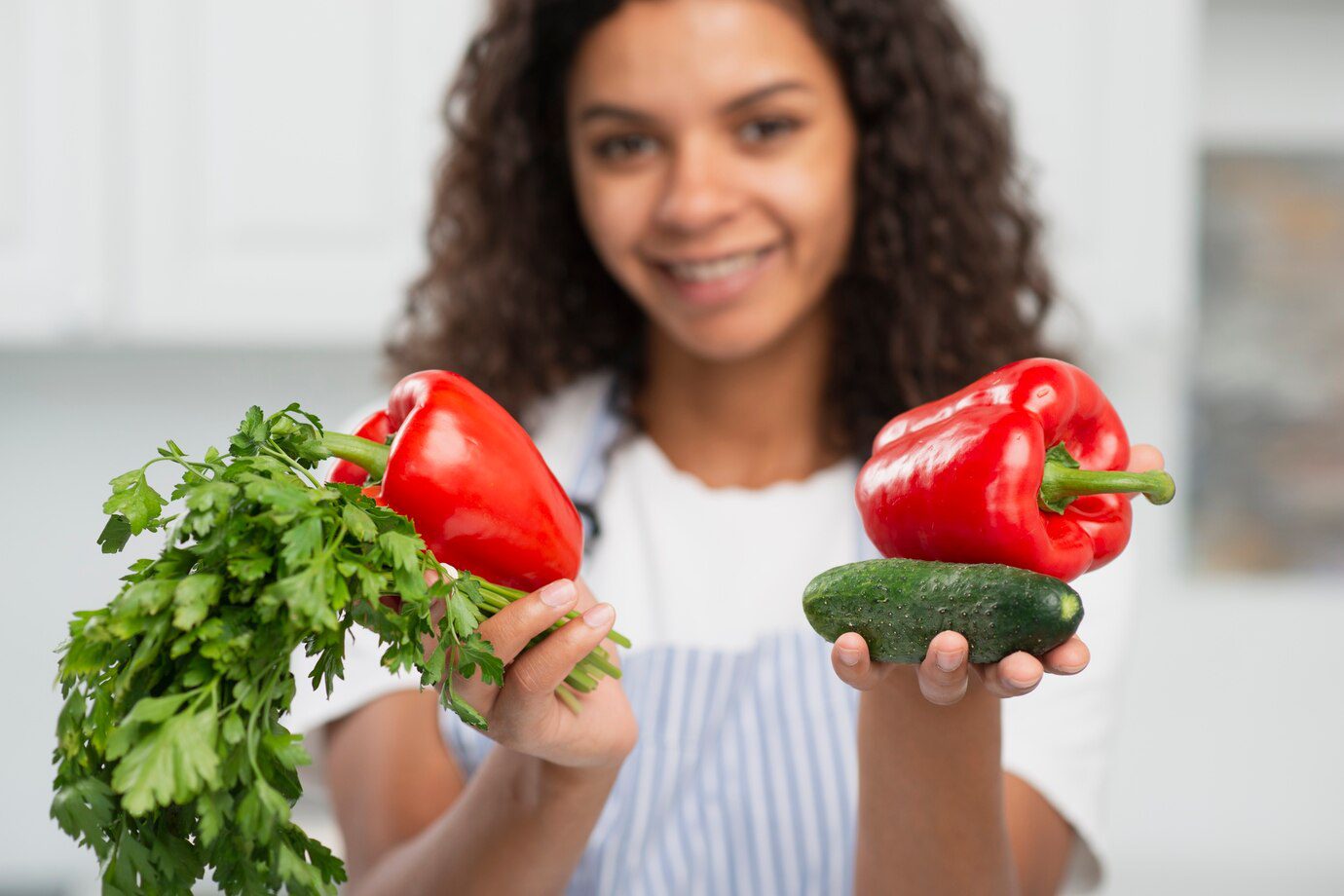 A woman holding two vegetables in her hands.