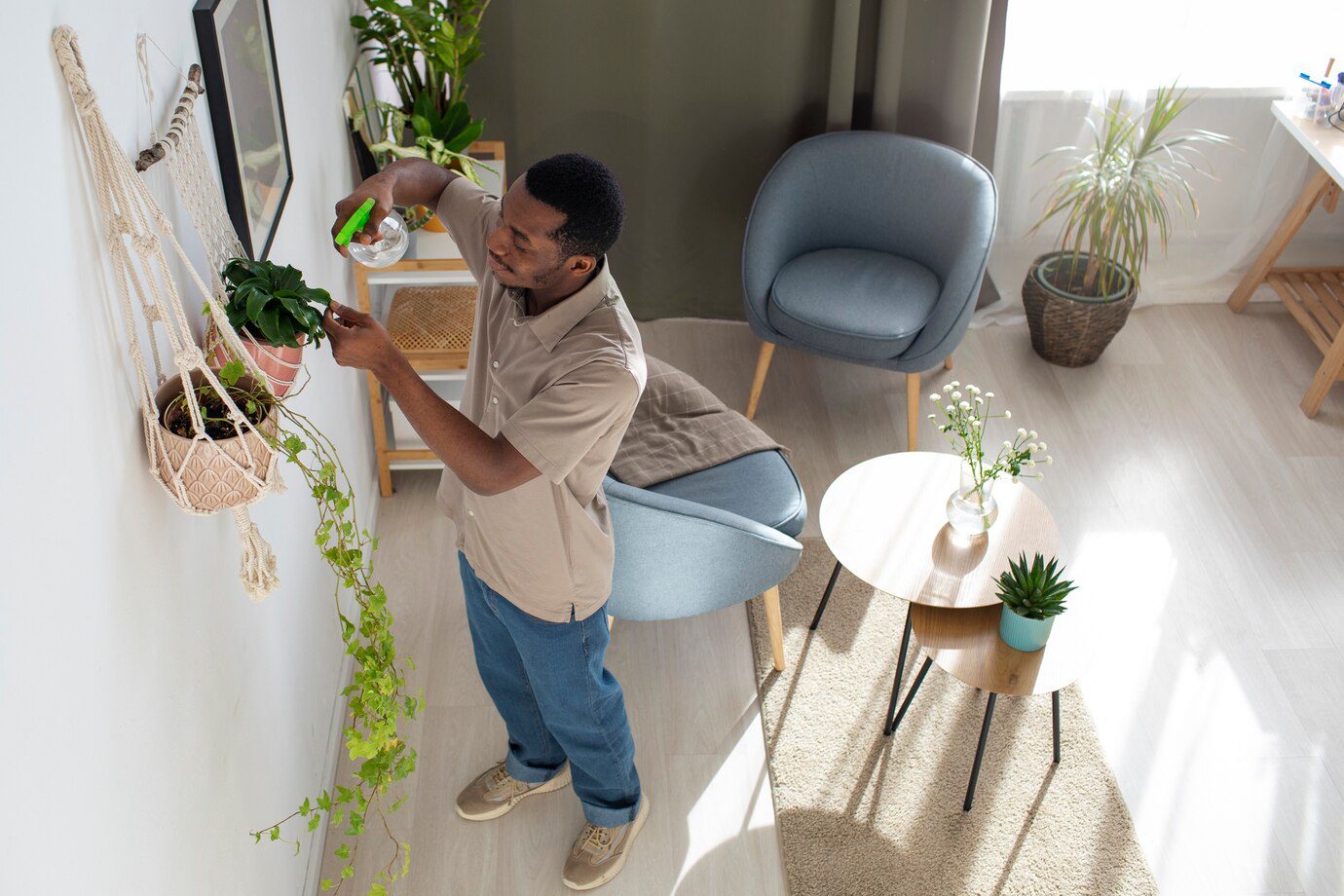 A man is hanging plants on the wall.