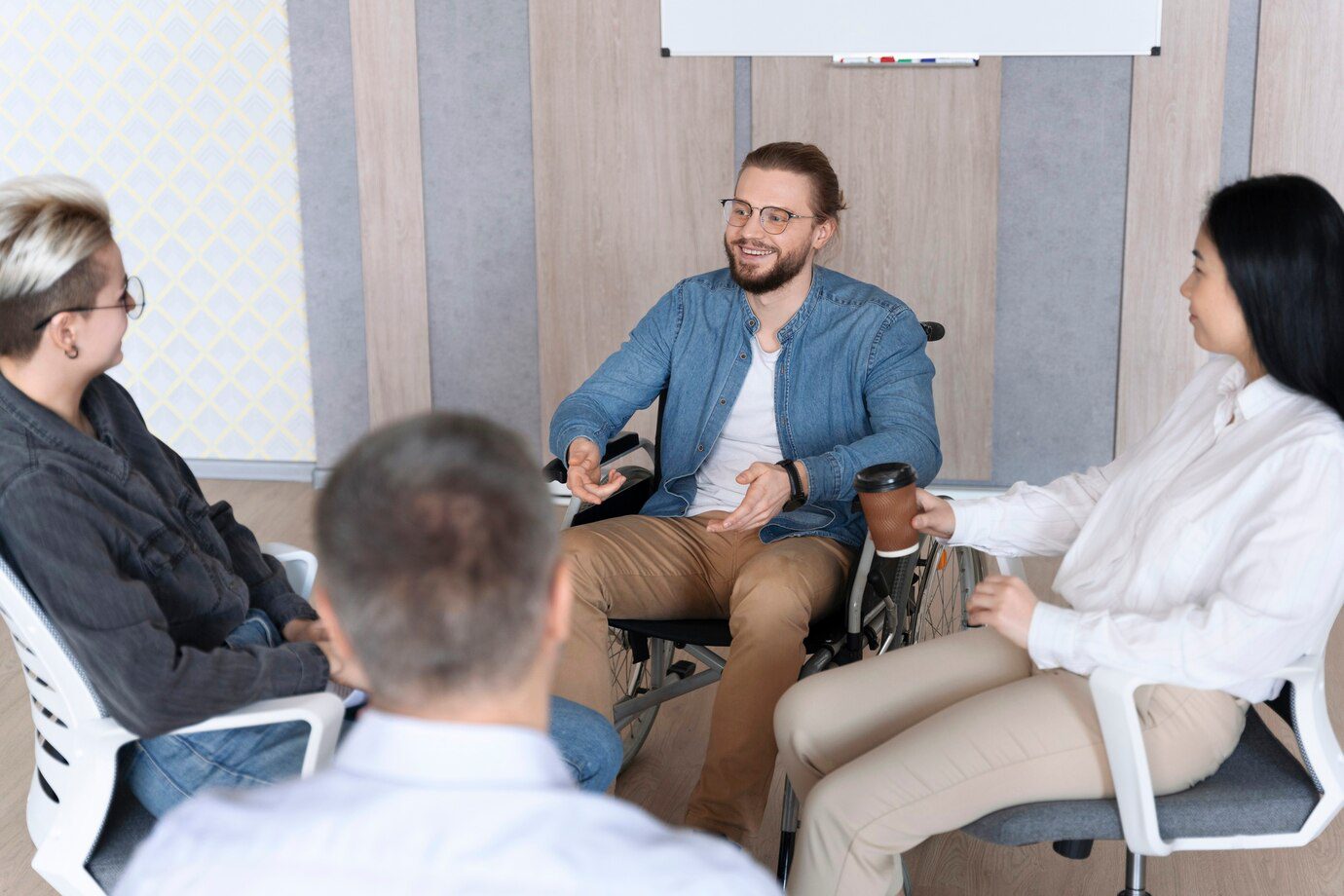 A group of people sitting around in chairs.