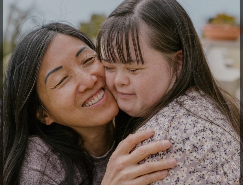 A woman and girl hugging each other.