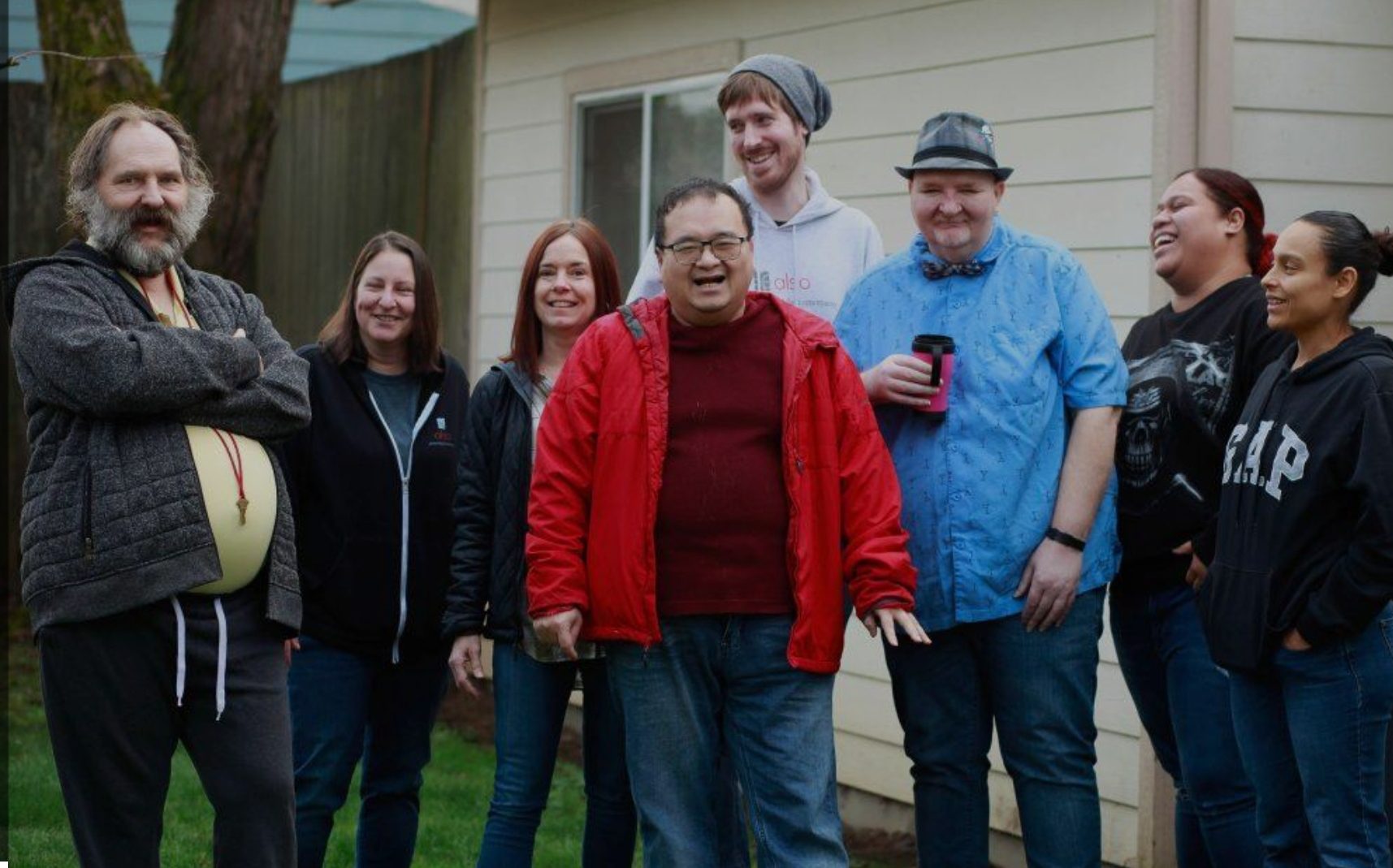 A group of people standing in front of a house.