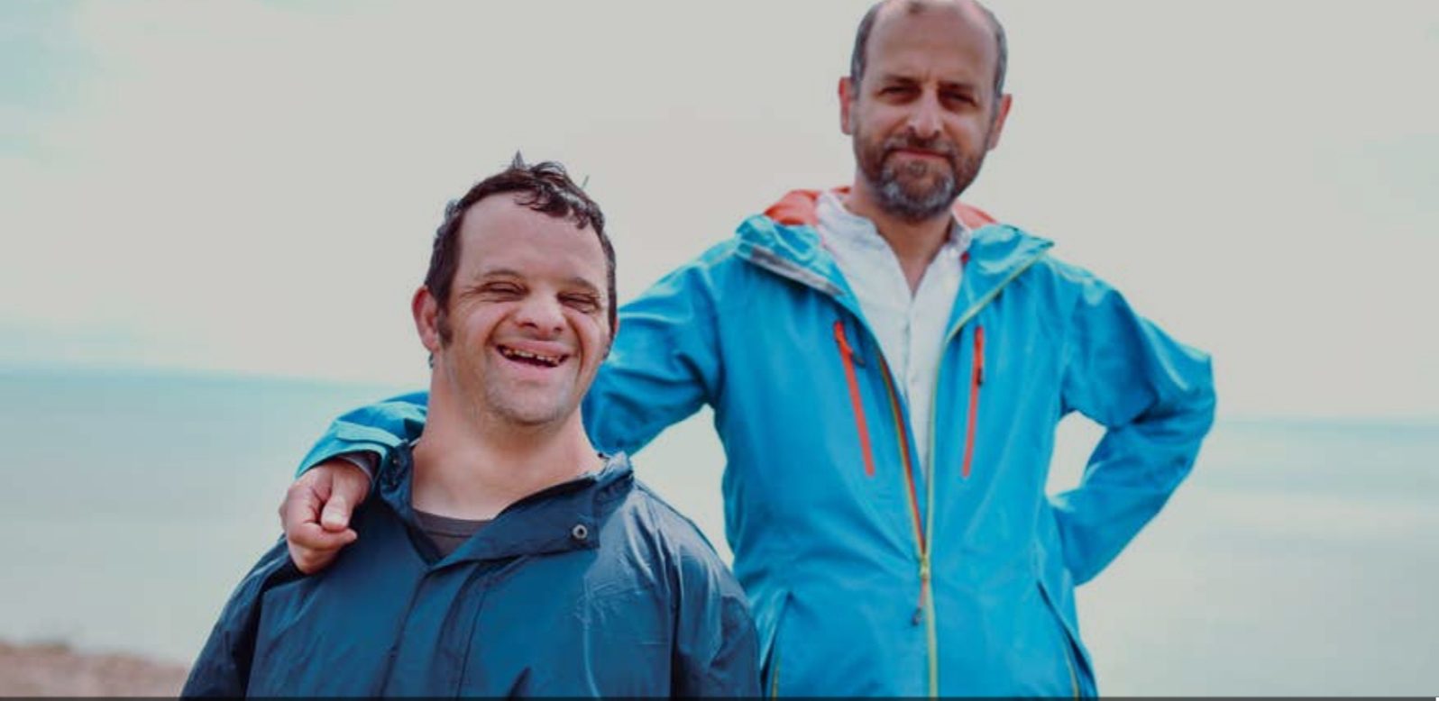 Two men standing next to each other in a field.